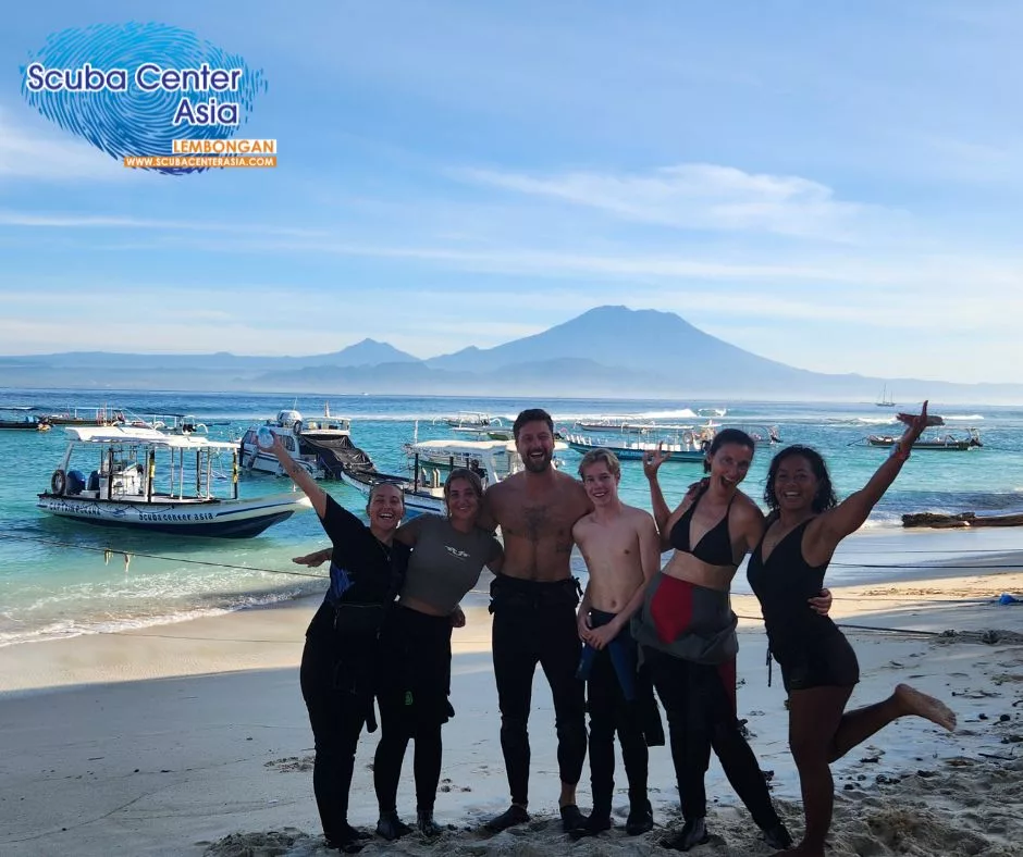 Happy IDC candidates standing on SCA's Mushroom beach with their feet in the sand and big smiles.