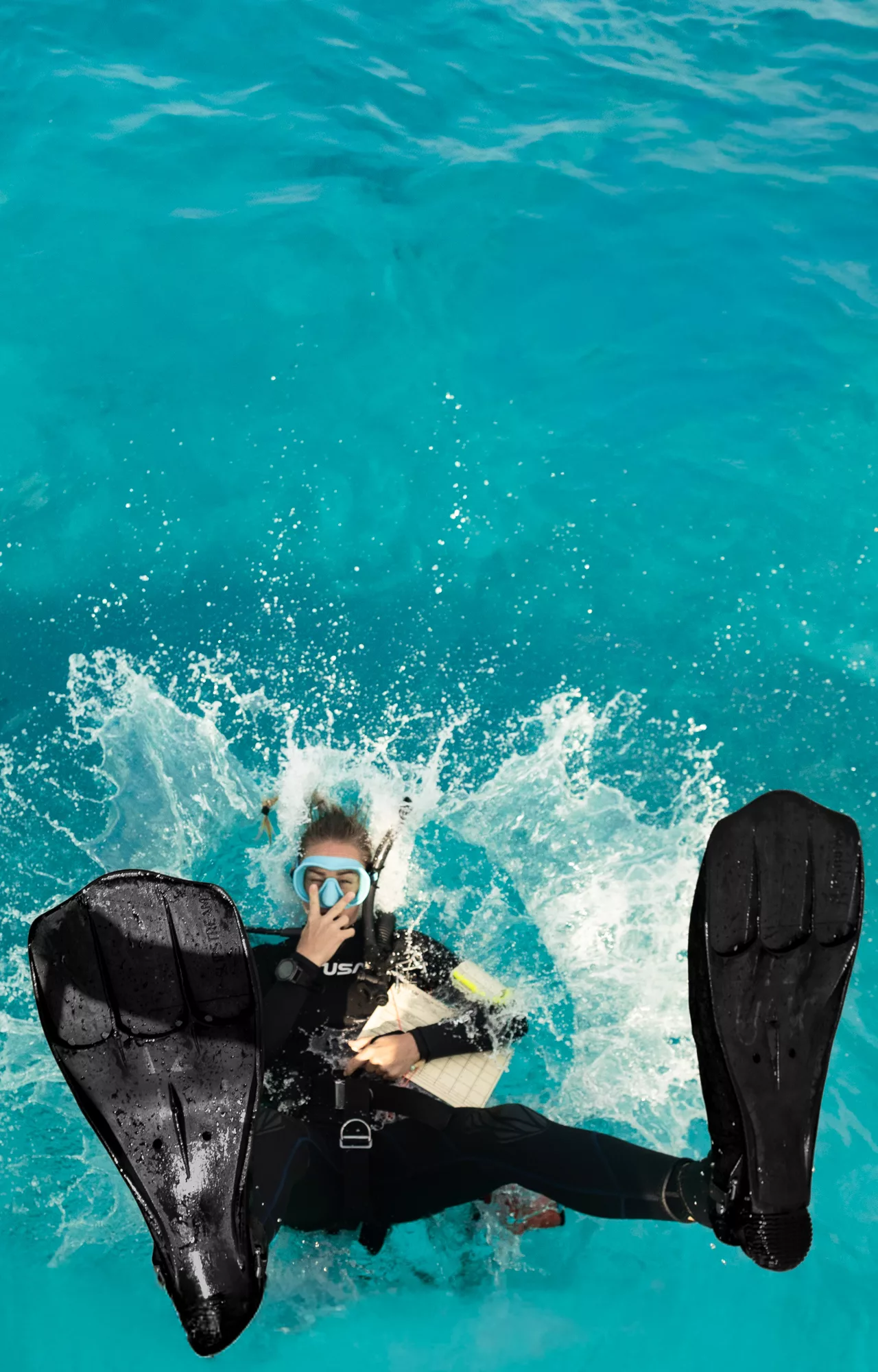 dive instructor jumps in the water to start teaching at scuba center asia