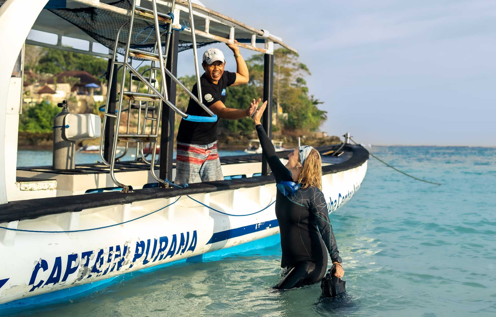 Captain and dive instructor happy high five on the scuba center asia boat