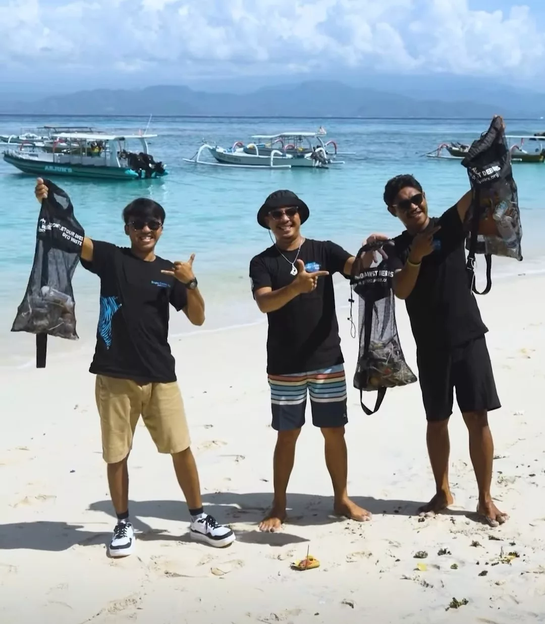 proud dive instructors showing the garbage collected during the monthly beach clean up by scuba center asia