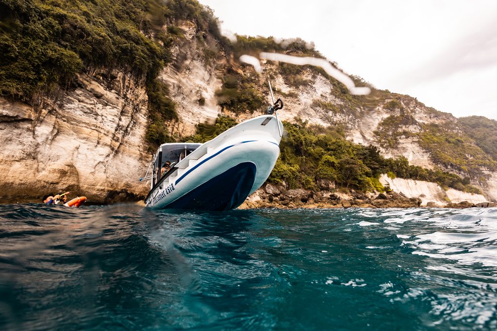 Diver and boat on mantapoint with beautiful scenery of Penida on background.